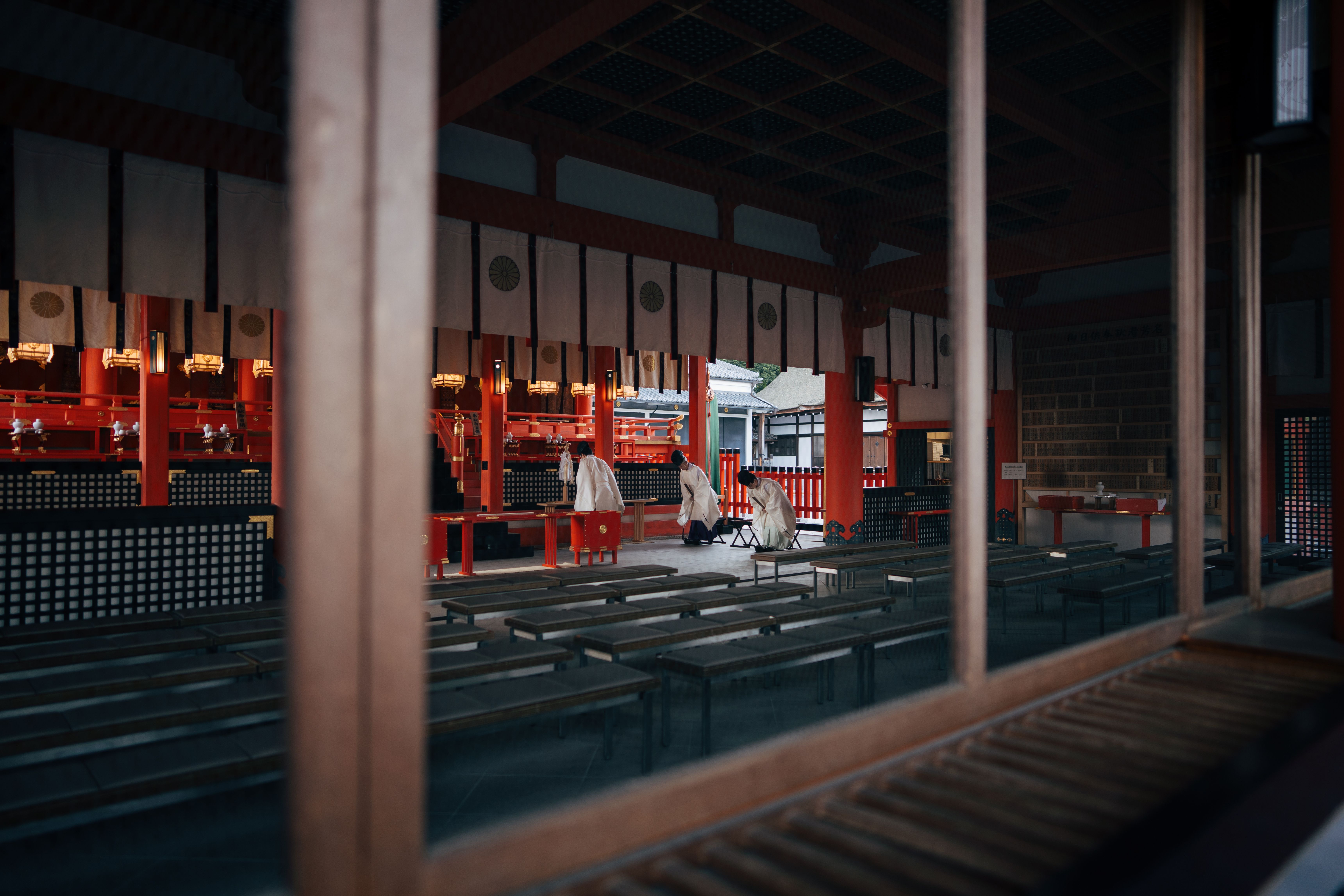 A serene moment captured inside a Kyoto shrine showing priests preparing for a traditional ceremony.