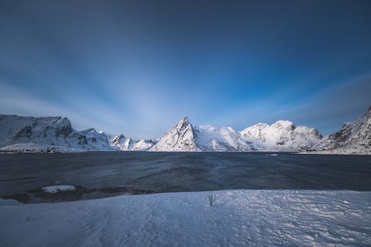 A breathtaking view of snowy mountains under a clear blue sky, captured during winter.