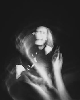 A black and white abstract photo capturing blurred motion of hands and a face.