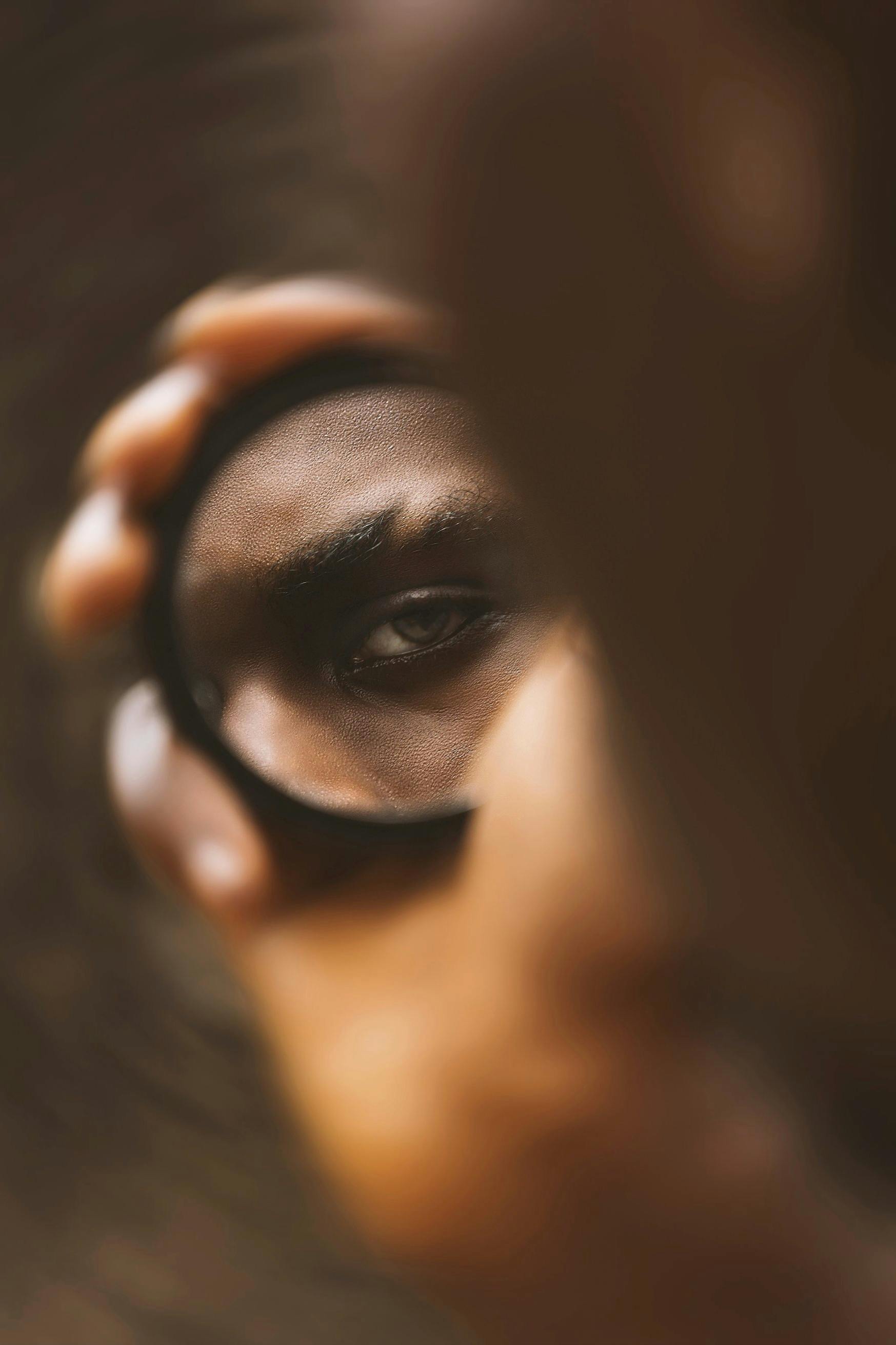 Gratis Cautivador primer plano del ojo de una persona reflejado en un espejo de mano, que invoca la introspección. Foto de stock