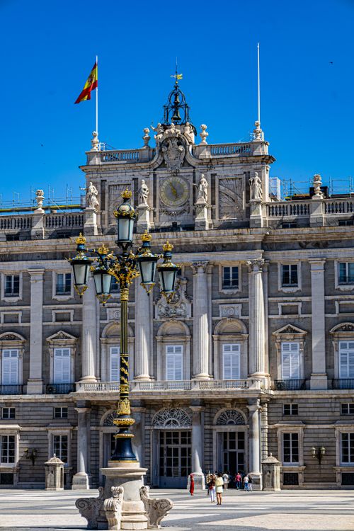Free Front view of the Royal Palace in Madrid on a sunny day with clear blue sky and decorative lamp post. Stock Photo