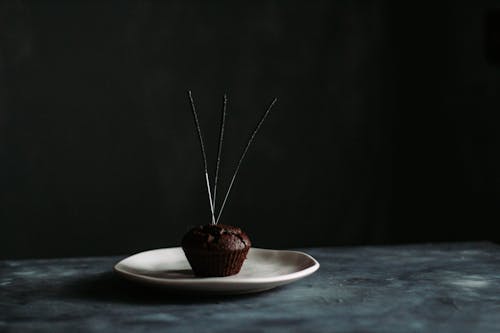 Chocolate muffin with firework sparklers on plate