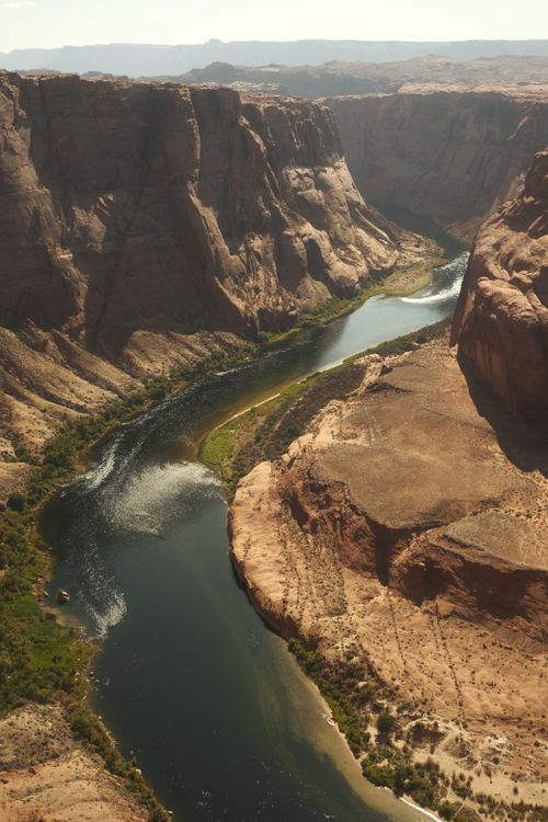Free Stunning aerial view of the Colorado River winding through massive canyon walls under daylight. Stock Photo