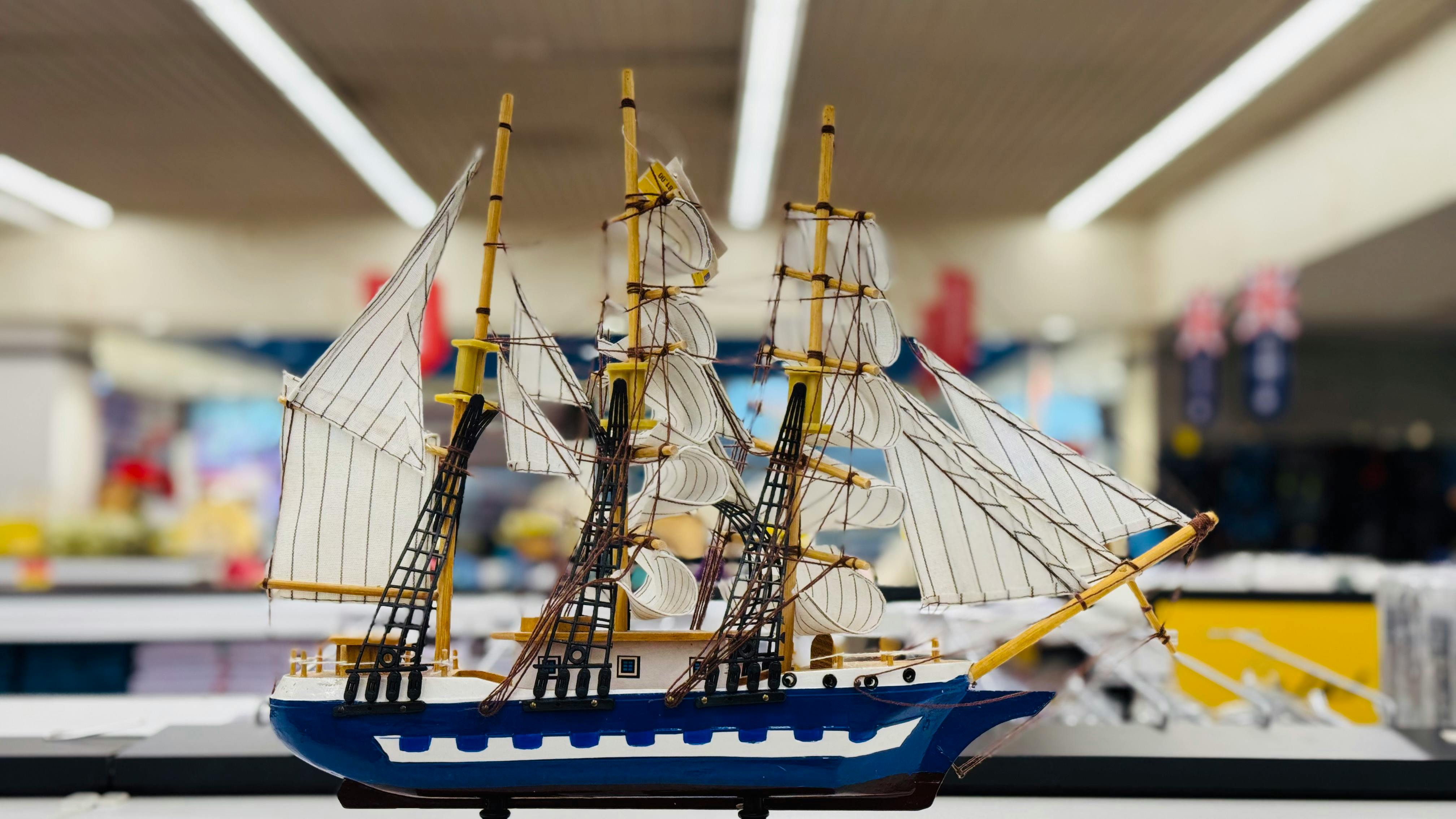 gratis Gedetailleerd model van een schip met zeilen, elegant tentoongesteld in een winkelschap. Stockfoto