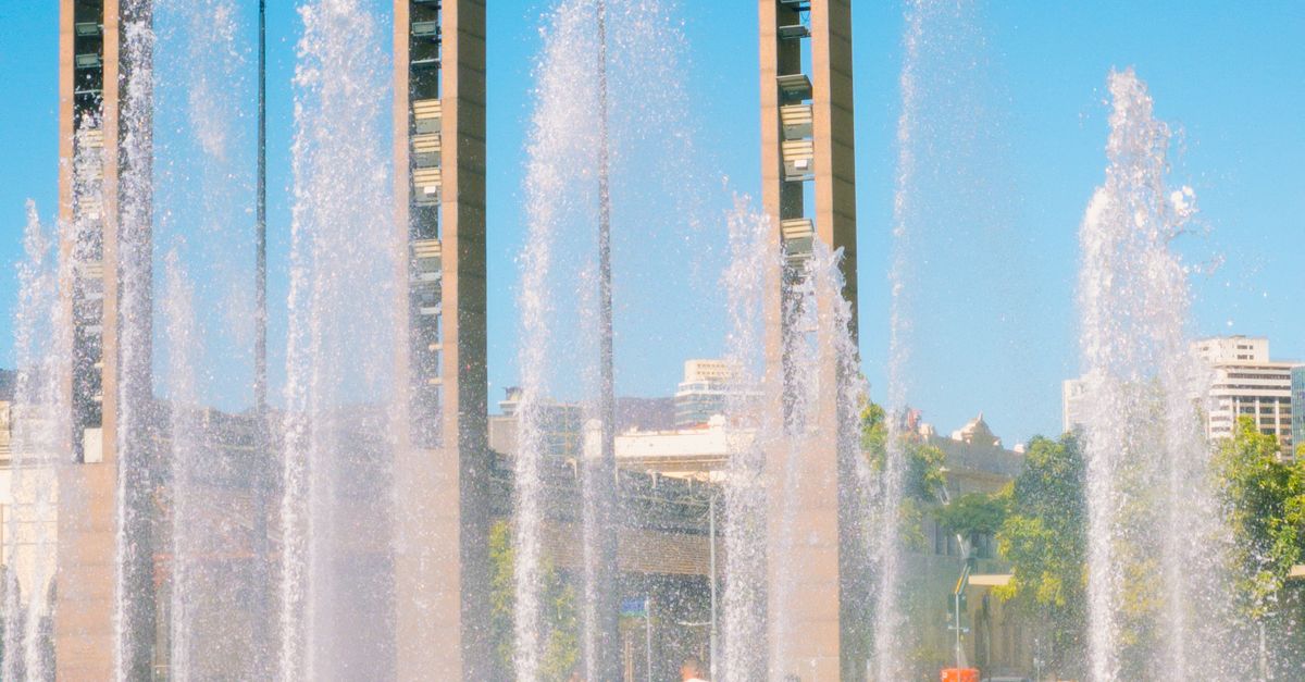 Crianças brincando em fonte de água ao ar livre, representando o uso consciente e a importância desse recurso na vida