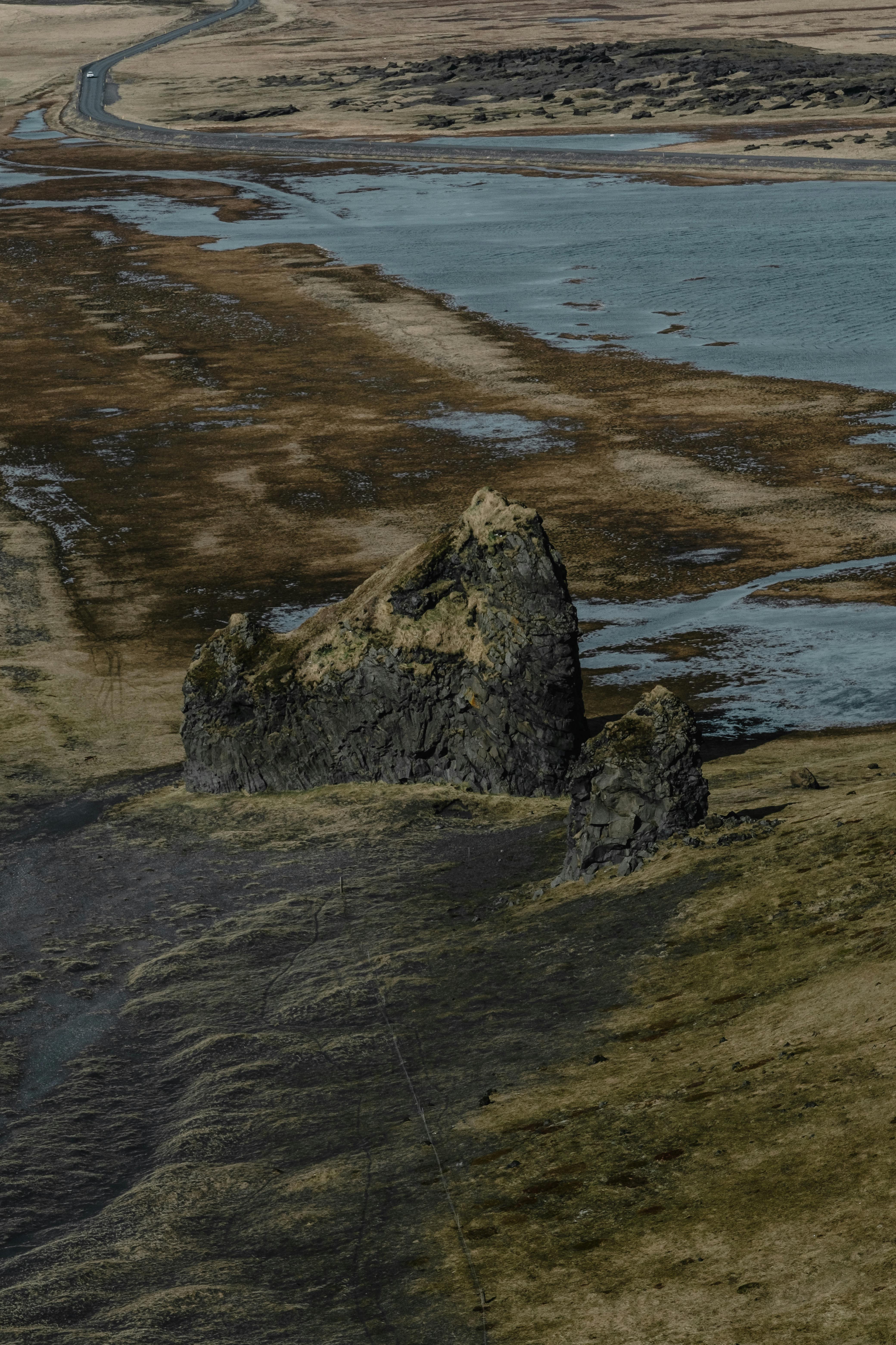 Aerial view of Icelandic rock formations by a river, showcasing the bleak beauty of nature.