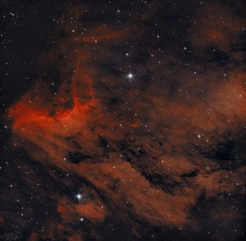 A stunning image of a nebula showcasing vibrant red hues in the vastness of space.
