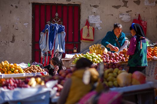 Women selling fresh fruits at an outdoor market. Colorful and lively street scene.
