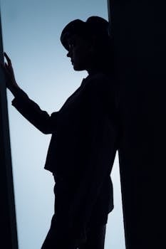 Dramatic silhouette of a fashionable woman with strong contrast lighting.