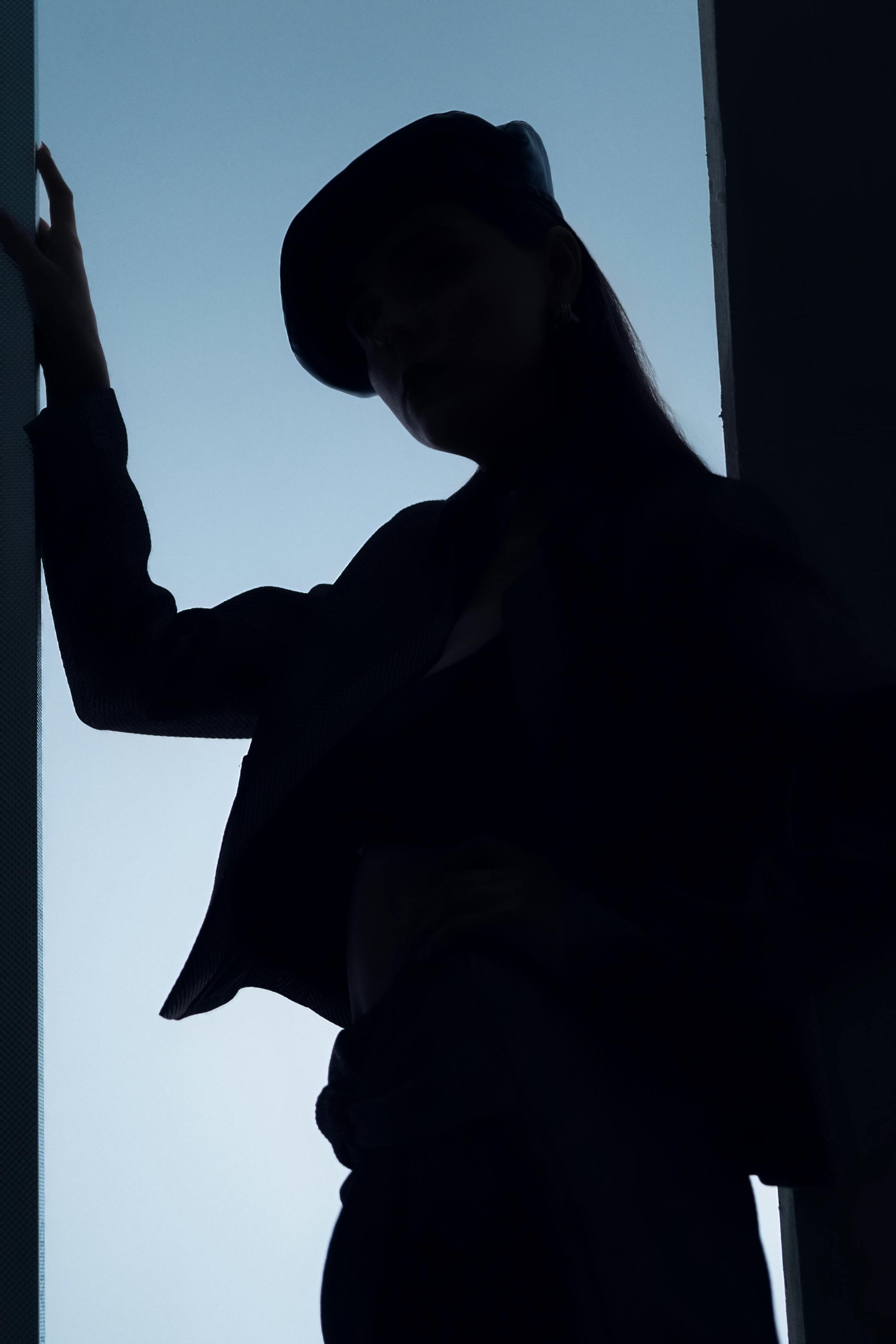 Free Edgy fashion silhouette of woman in urban setting with soft lighting, creating a high fashion mood. Stock Photo