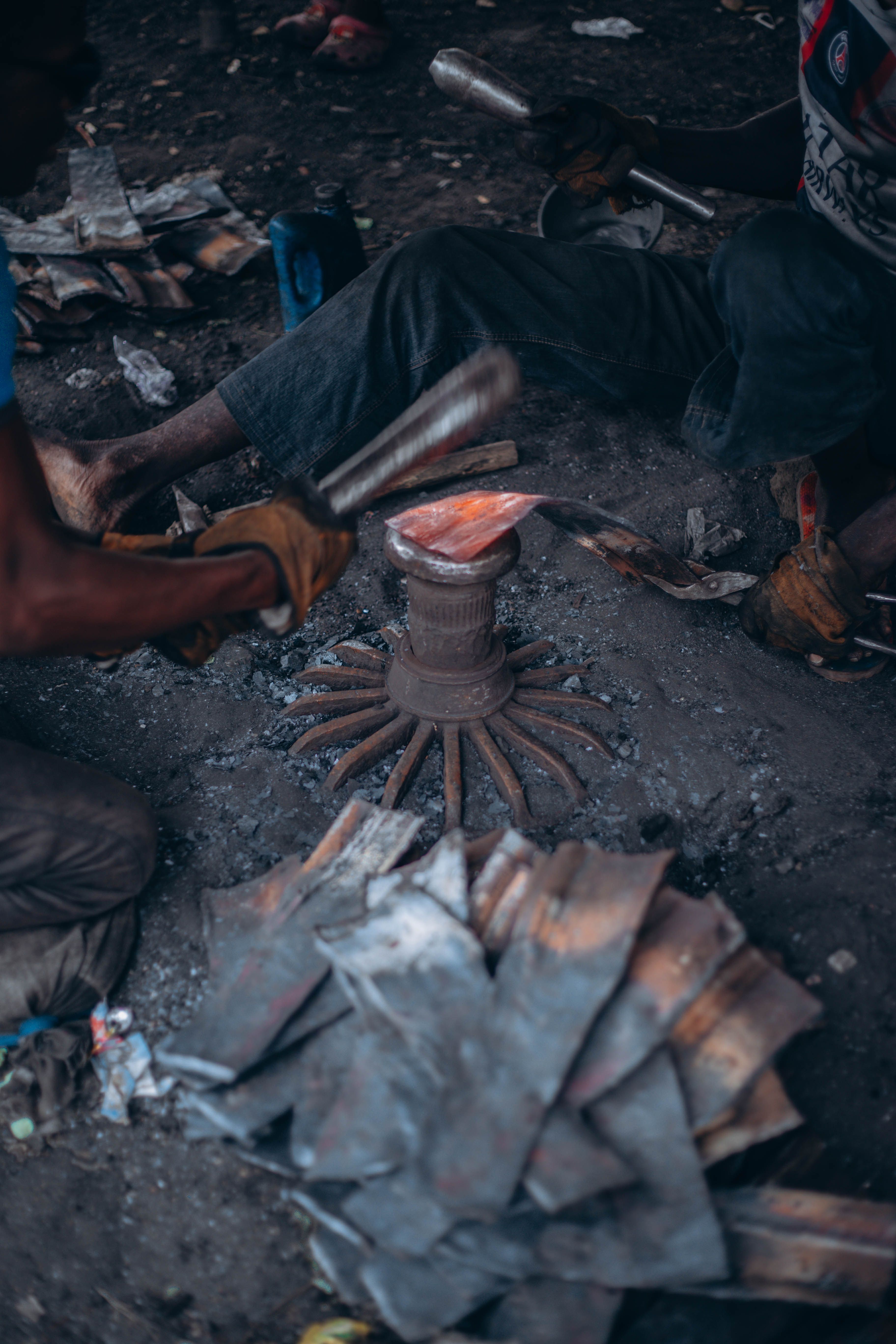 Artisans skillfully shape metal in a traditional, rustic workshop setting.