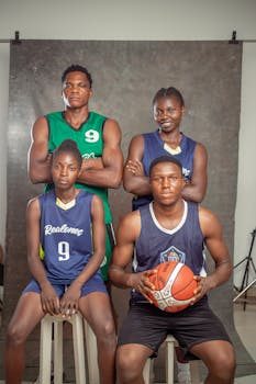 Portrait of a diverse basketball team posing in uniform indoors.