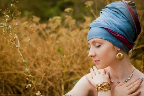 Woman Wearing Blue Turban Sitting Near Brown Field