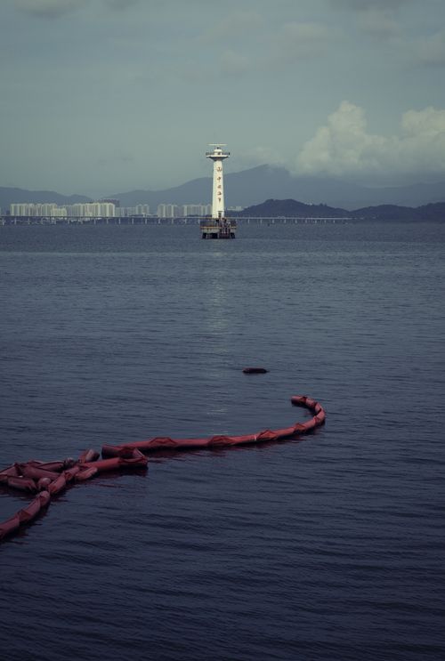 Free View of a coastal observation tower surrounded by calm sea and distant skyline. Stock Photo
