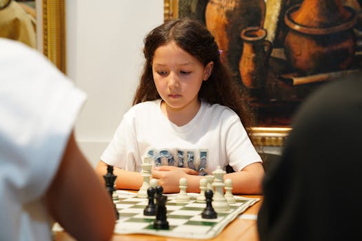 Young girl intently playing a chess game indoors, concentration evident.