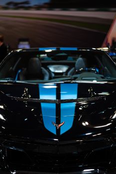 Close-up of a Chevrolet Corvette with black and blue detailing at a Toronto auto show.