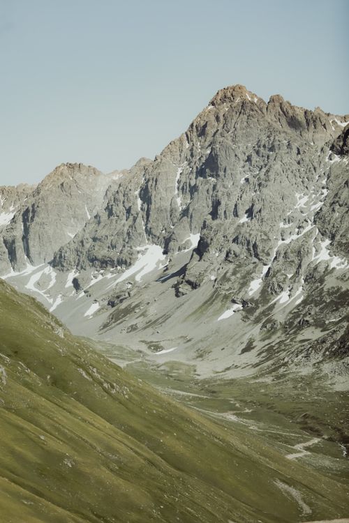 Free A breathtaking view of rugged Alpine mountains with green valleys below. Stock Photo