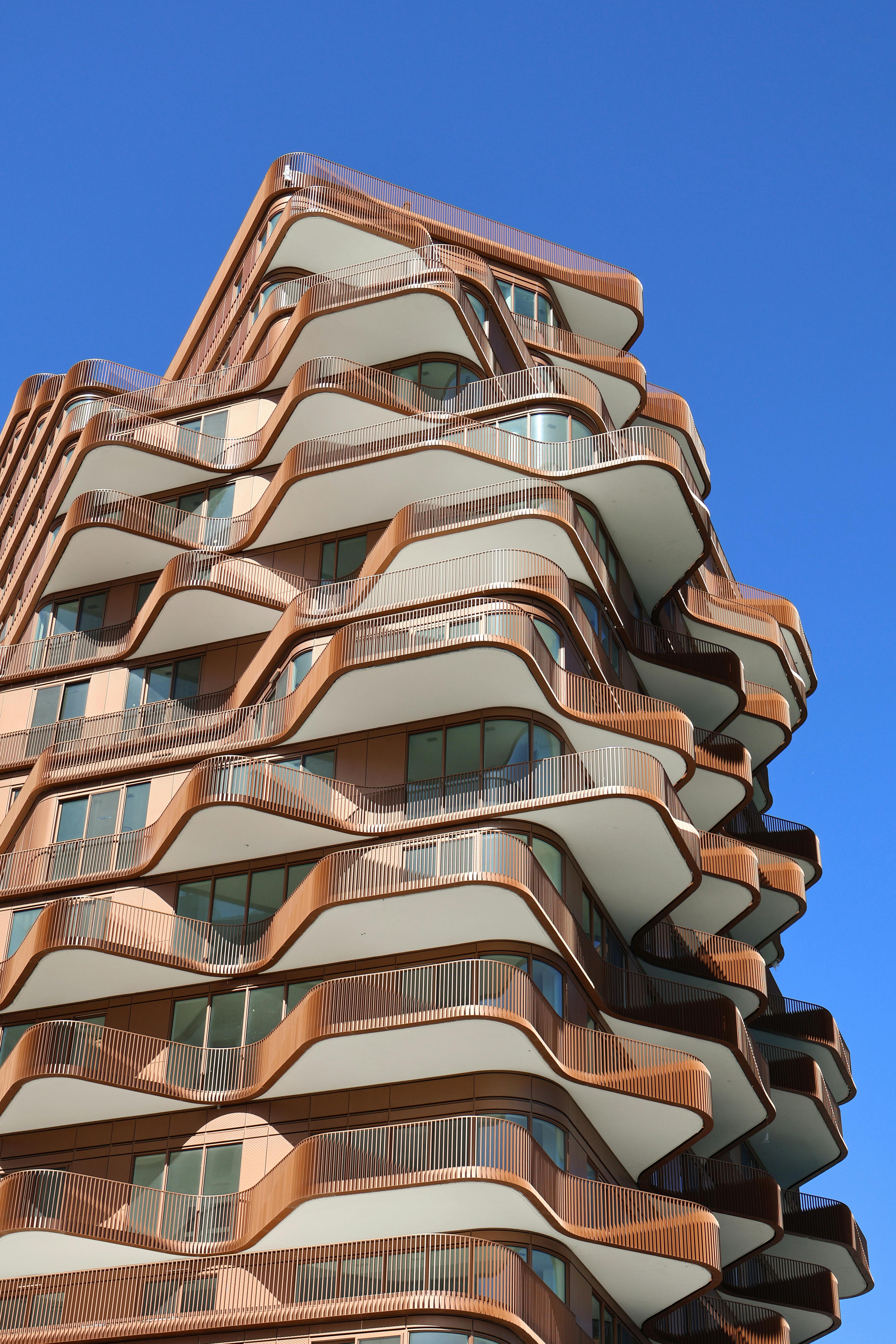 Unique wavy apartment building design under a clear blue sky in Toronto, Canada.