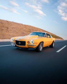 Classic yellow sports car cruising on a highway near Ankara, Türkiye in daylight.