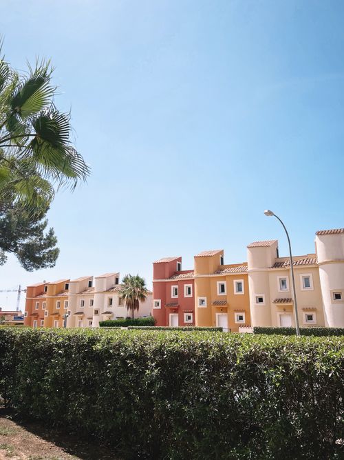 Free Vibrant Mediterranean homes with pastel colors and geometric designs under a clear sunny sky. Stock Photo