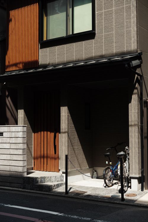 Free A bicycle parked in the shadow of a traditional Kyoto house entrance, Japan. Stock Photo