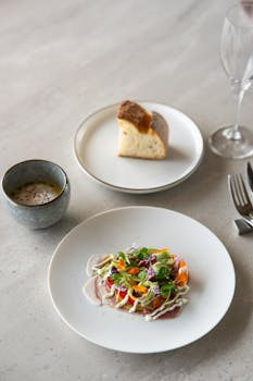 Plate of fine dining cuisine with bread and drink served in a stylish Tokyo restaurant.