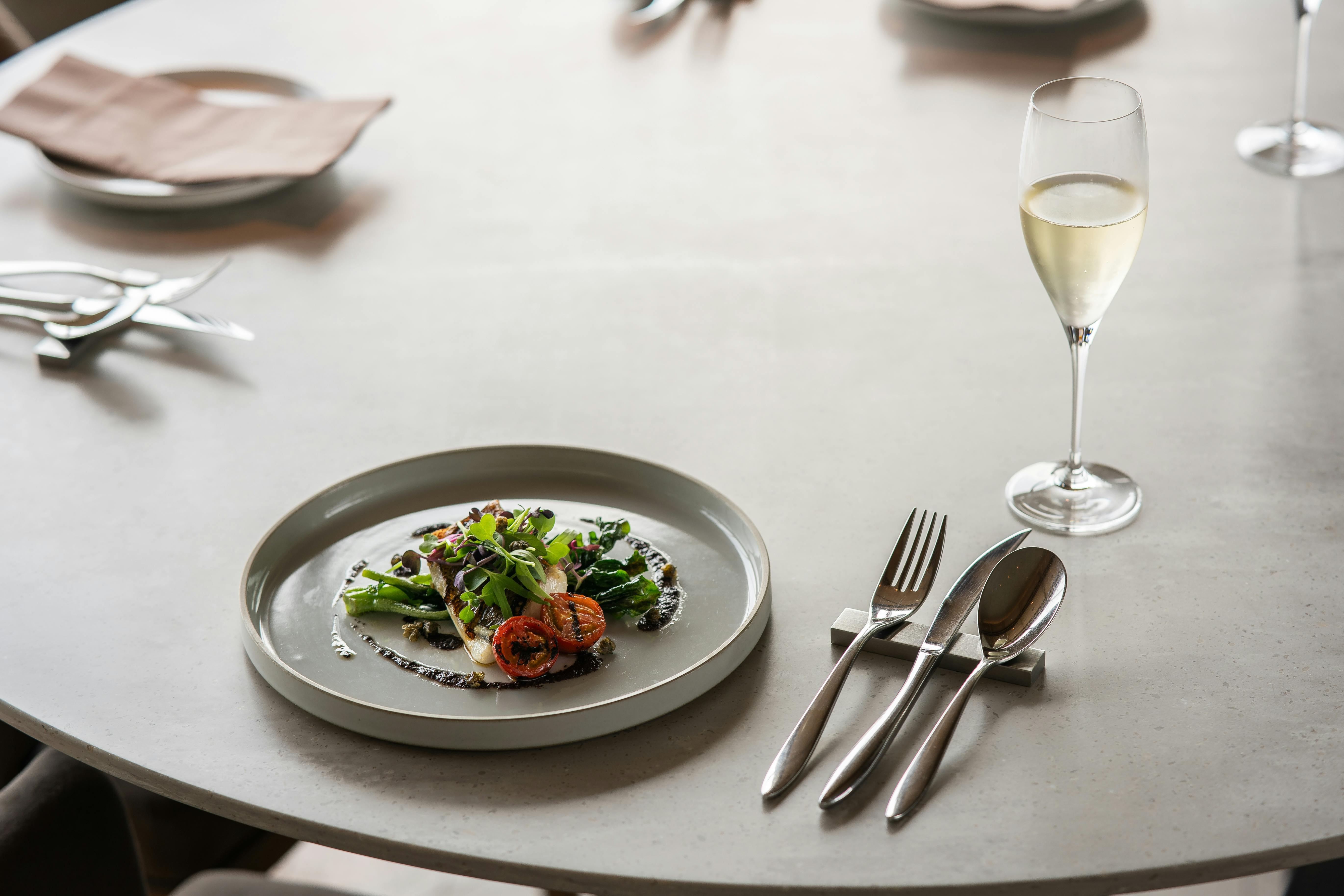 A sophisticated table setting with gourmet dish and champagne glass in a luxurious Tokyo restaurant.