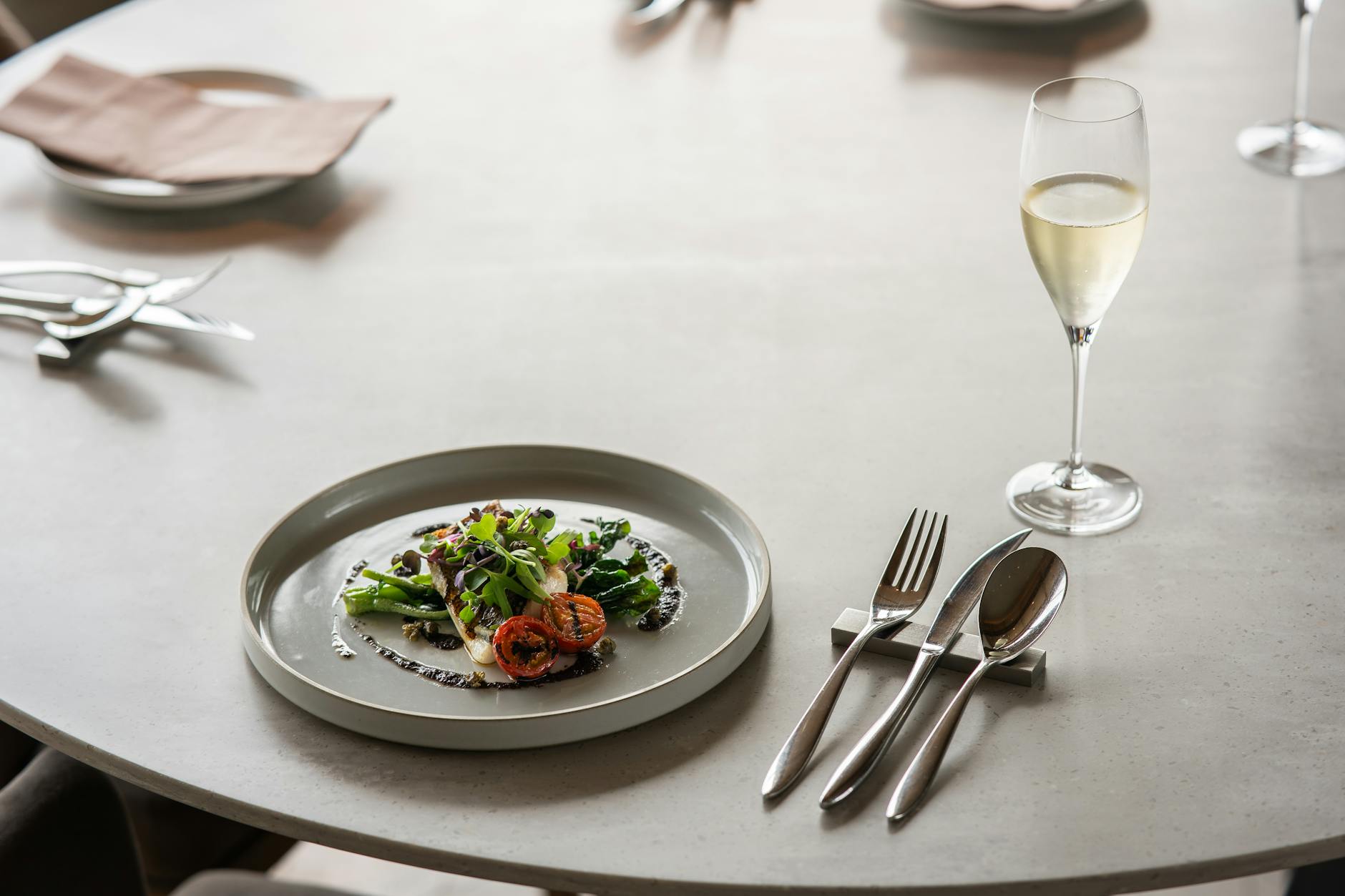 A sophisticated table setting with gourmet dish and champagne glass in a luxurious Tokyo restaurant.