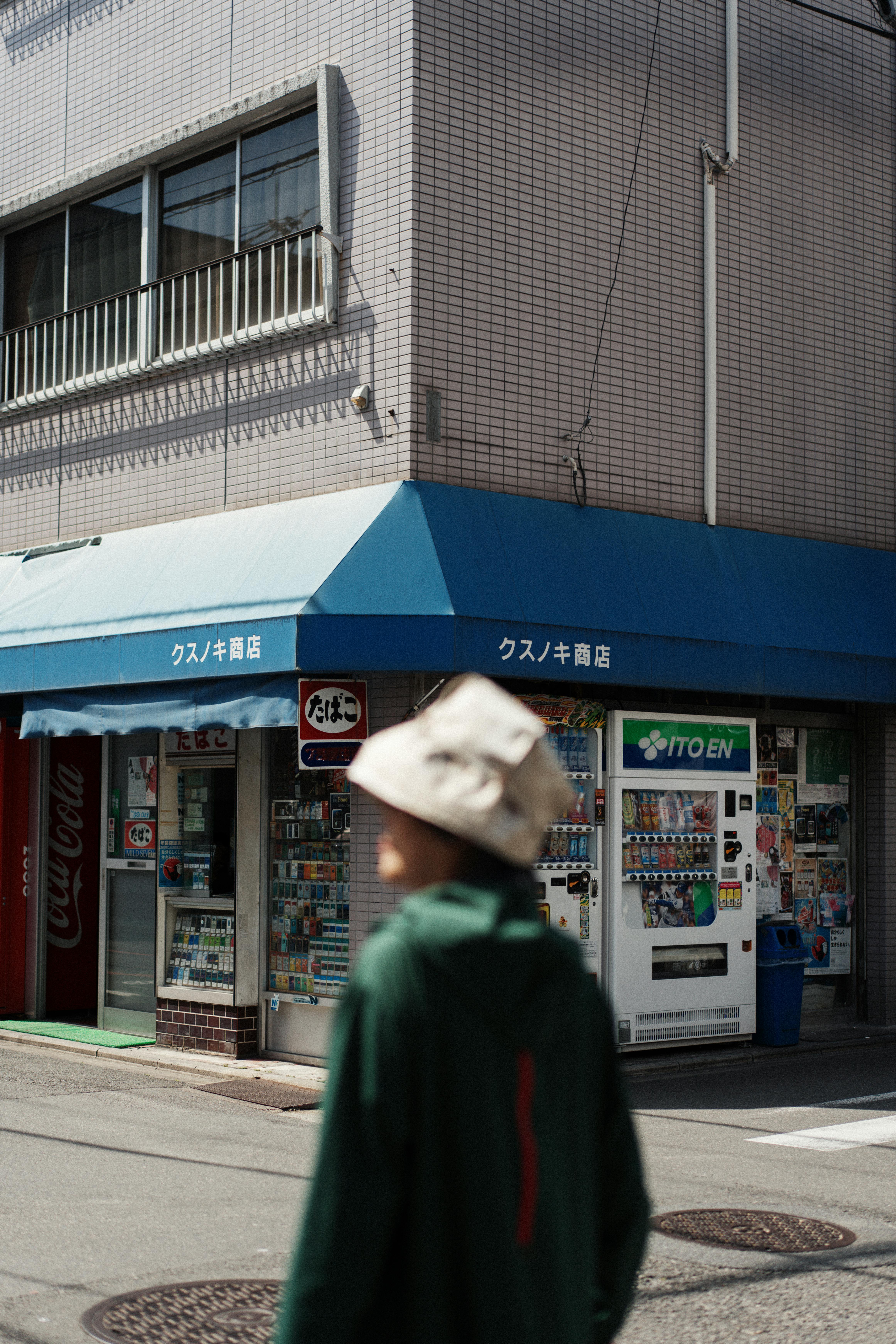 A candid street view in Kyoto featuring a local shopfront and pedestrian.