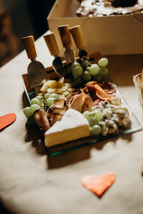 Free A delicious cheese and charcuterie platter featuring various cheeses, meats, and green grapes, perfect for Valentine's Day. Stock Photo