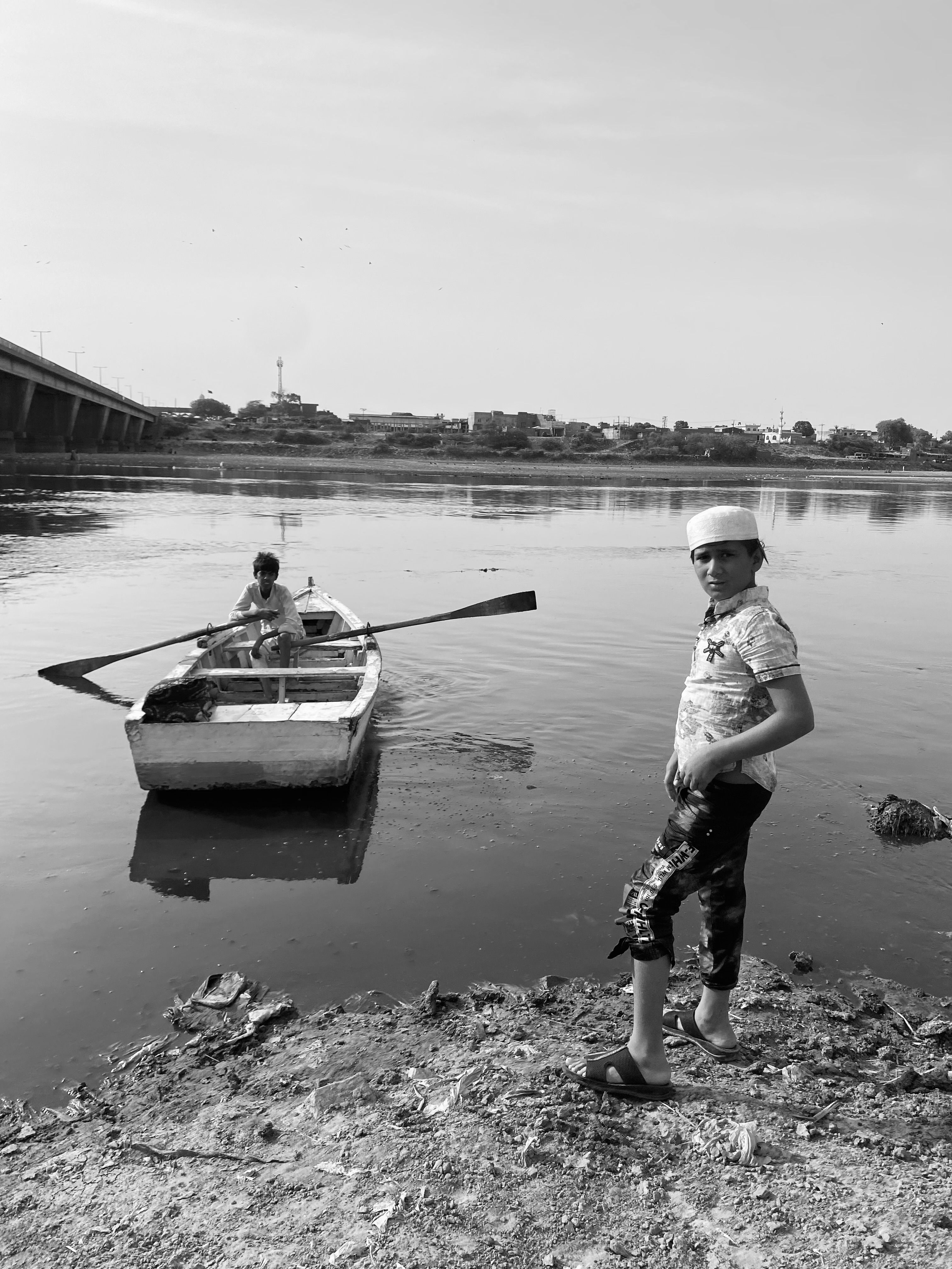 Two boys with a boat on the Ravi River in Lahore, Pakistan.