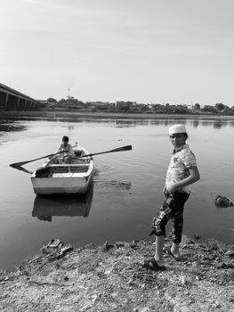 Two boys with a boat on the Ravi River in Lahore, Pakistan.