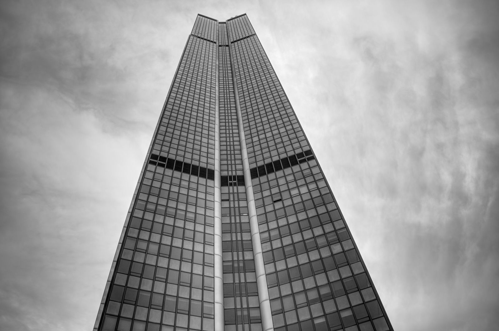 Striking view of a Paris skyscraper reaching into a dramatic cloudy sky