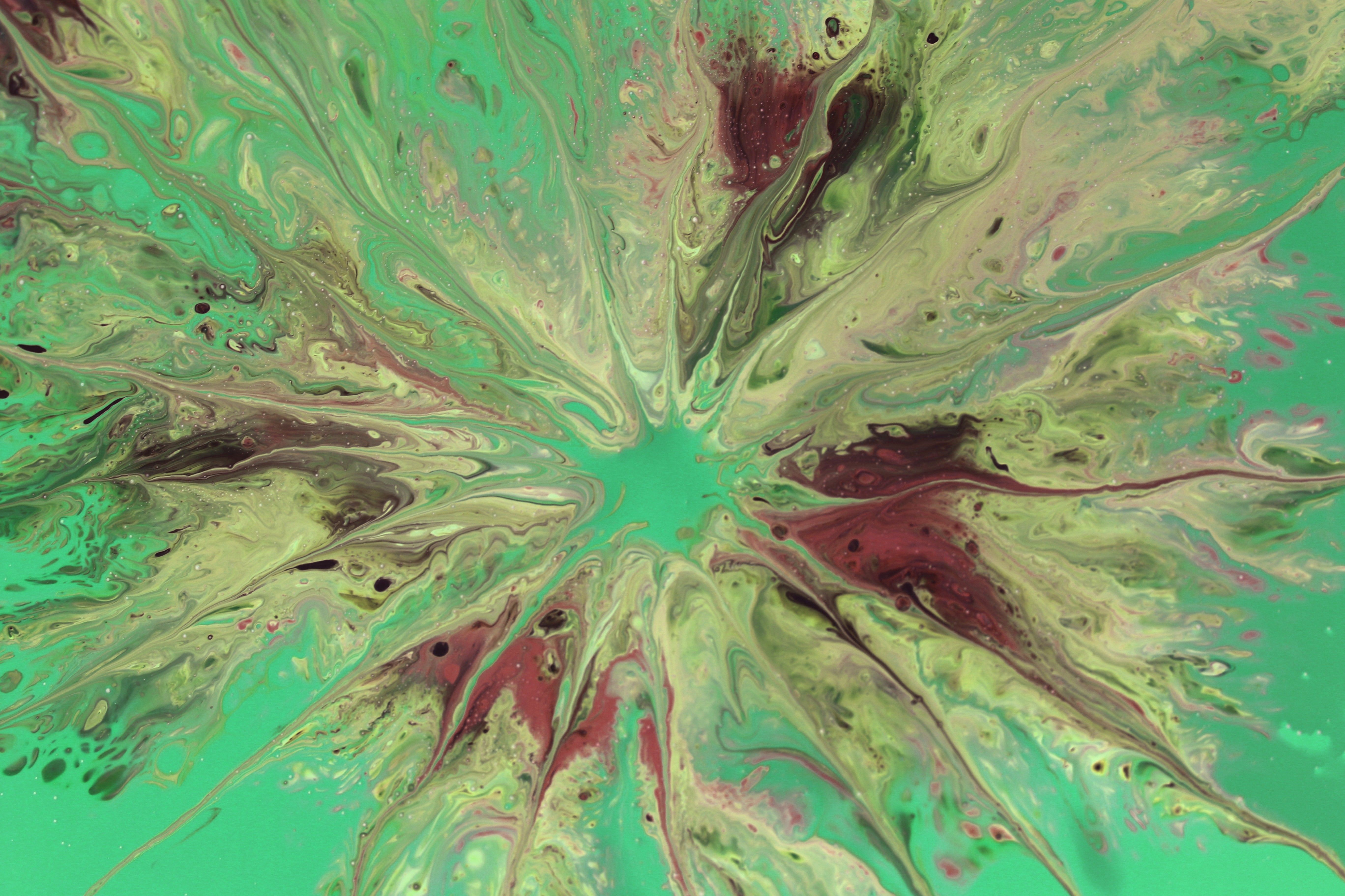 Abstract fluid art featuring vibrant green and red swirls in a dynamic composition.
