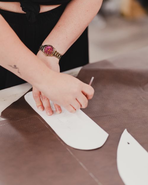 Free Close-up of a tailor's hands working meticulously with a pattern on brown leather, showcasing precision crafting. Stock Photo