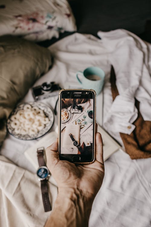 Persona Que Toma La Foto De La Comida En La Cama