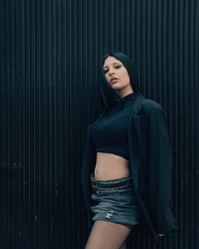 Portrait of a fashionable young woman posing against a textured wall in Buenos Aires.