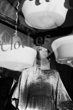 时尚店橱窗里，人体模型穿着优雅黑白照片，表面带有反光效果