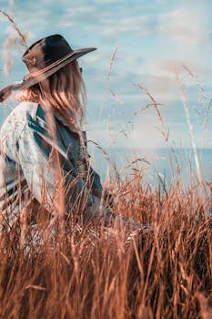 这幅宁静的肖像描绘了一位戴帽子的女人，在泰恩茅斯的草地上享受夏日时光