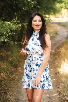 A woman in a floral dress enjoying a sunny day outdoors.