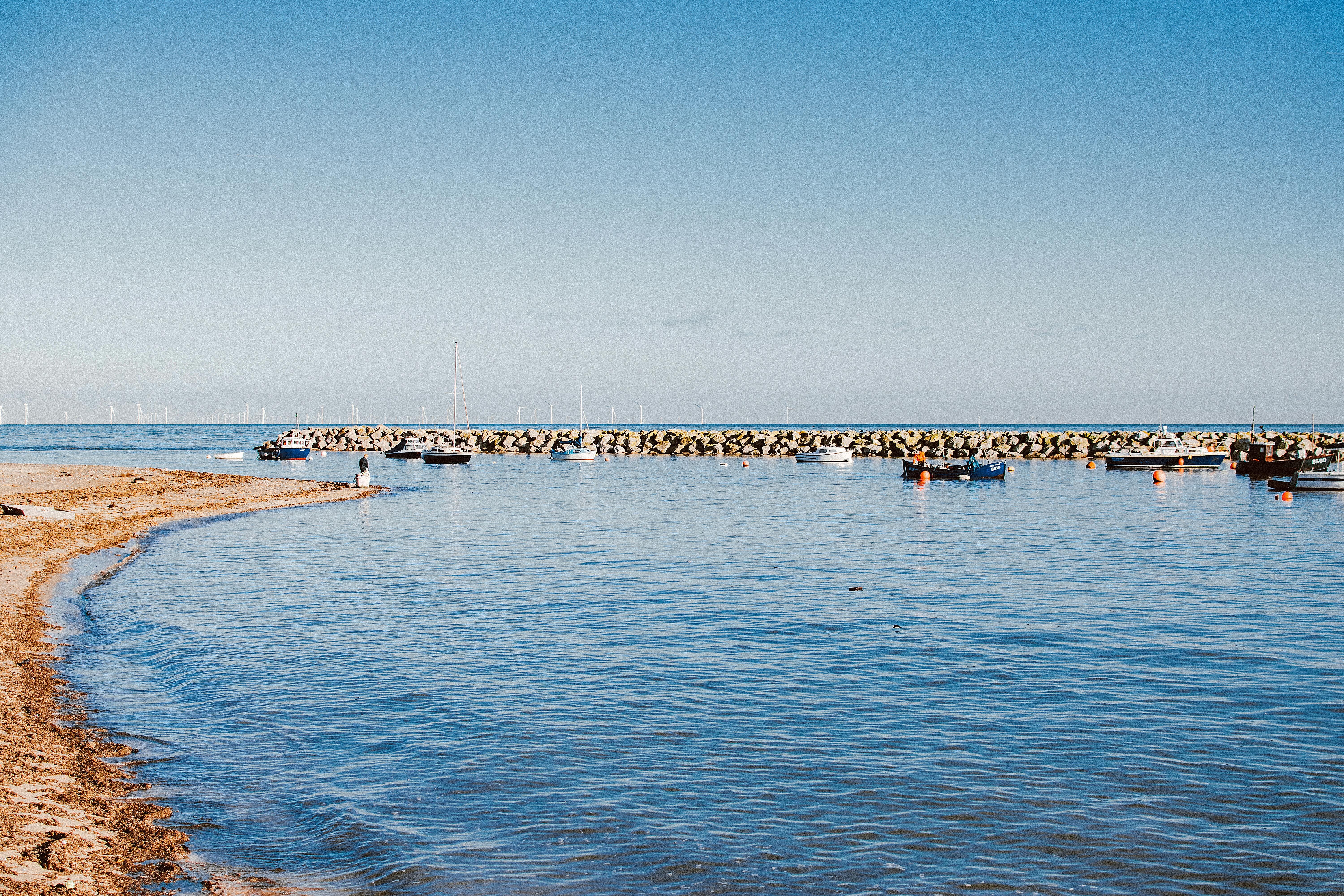 A serene coastal view of boats anchored at Rhos on Sea harbor in Wales.