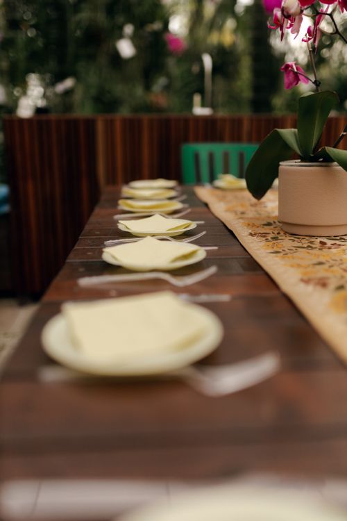 Free A beautifully arranged dining table with an orchid centerpiece and neatly set plates and napkins. Stock Photo