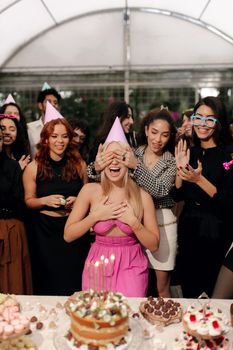 A lively birthday party with friends, cake, and laughter in a festive indoor setting.
