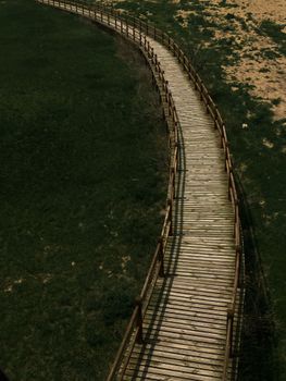 Aerial view of a winding wooden walkway through grassy fields in Kayseri, Türkiye.