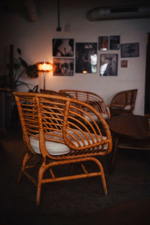 Free Warm and inviting cafe interior featuring stylish rattan chairs and ambient lighting. Stock Photo