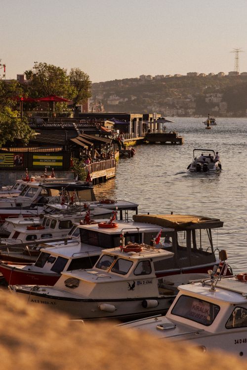 Free Idyllic river scene with docked boats and golden hour lighting creating a warm ambiance. Stock Photo