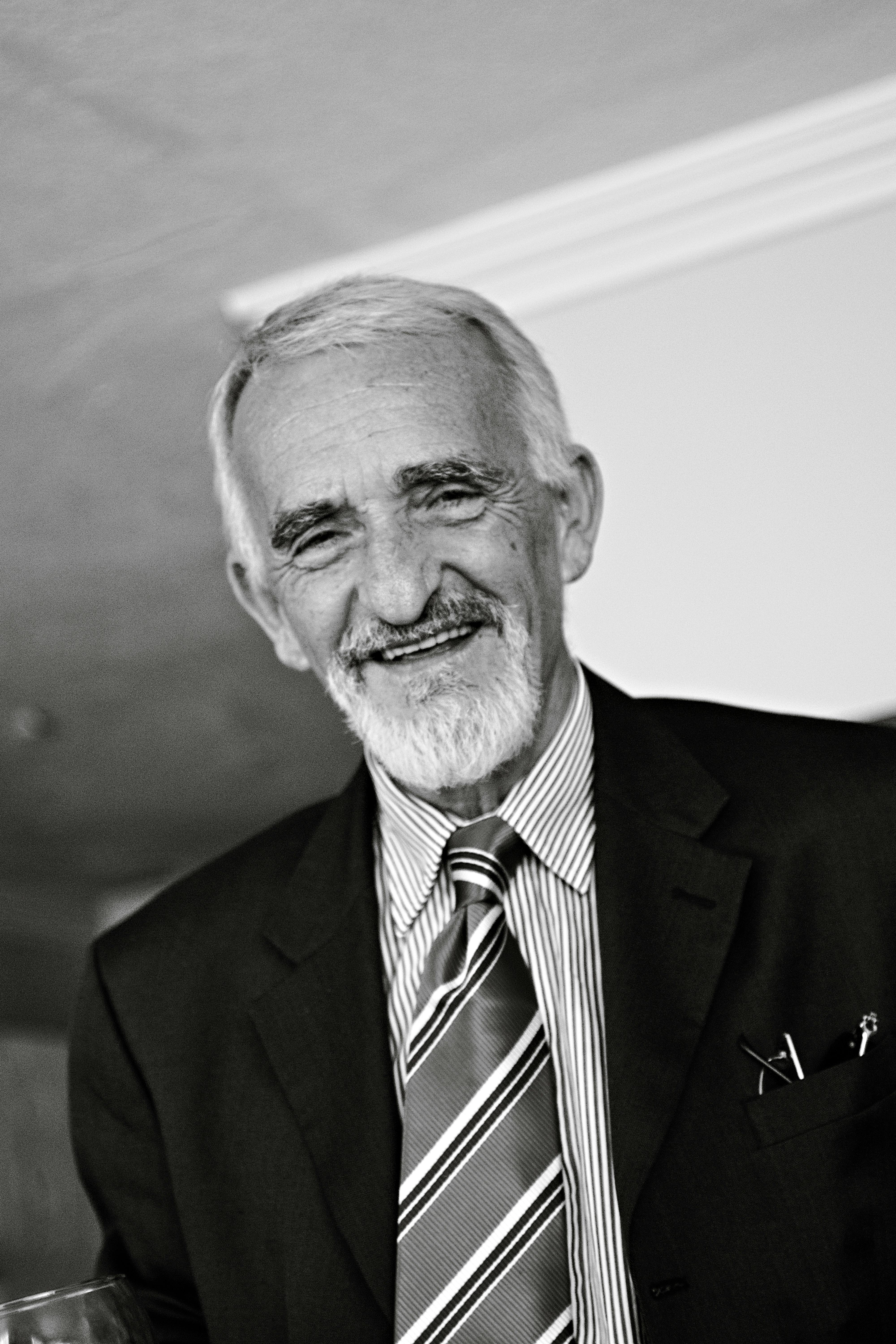 Elegant black and white portrait of a senior man in a suit, exuding charm and wisdom.