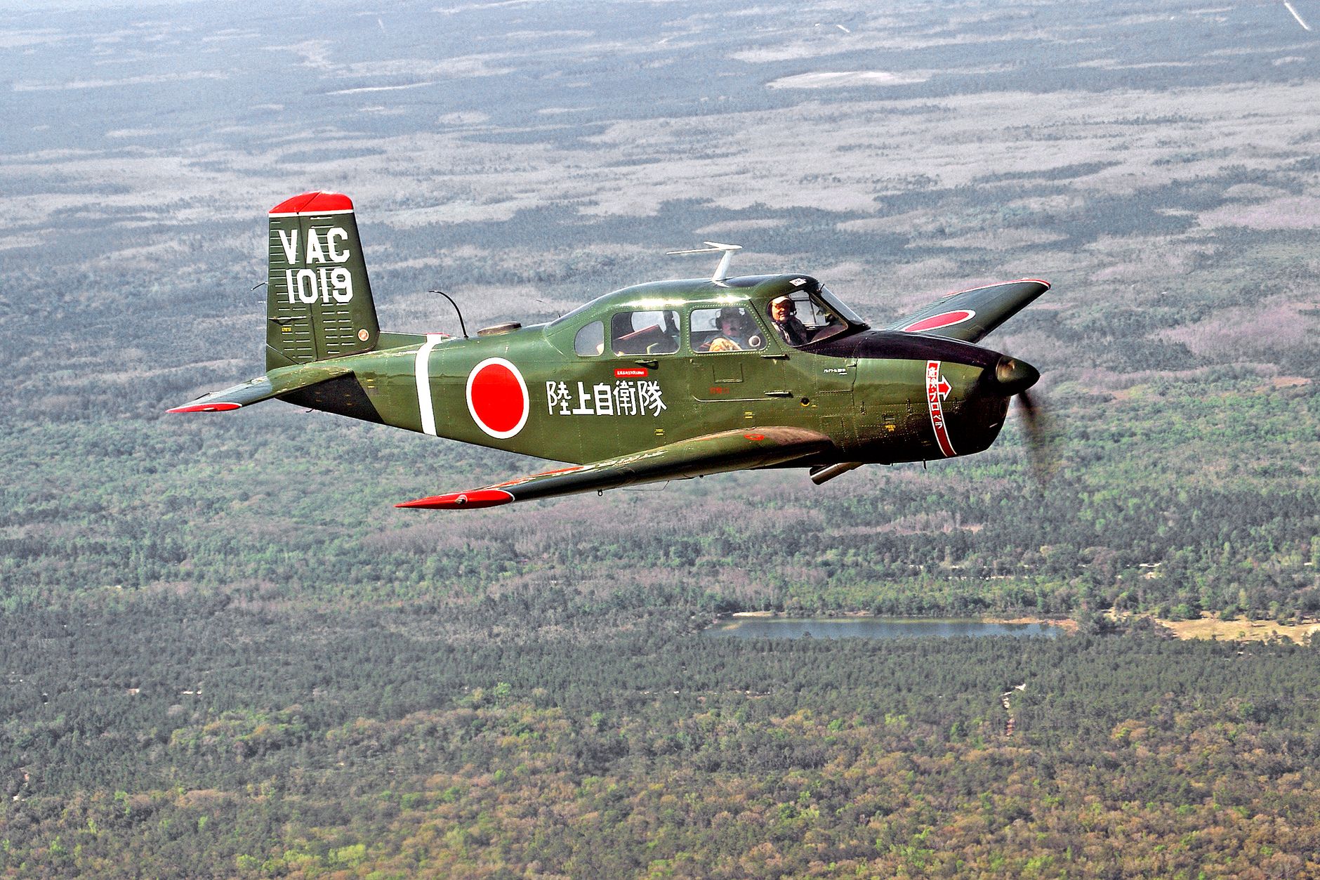 A vintage LM-1 aircraft flying over the scenic landscape of Titusville, Florida.
