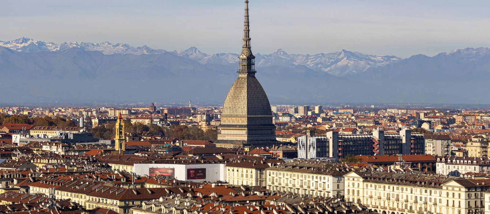 Discover the stunning cityscape of Turin with the iconic Mole Antonelliana and the Alps in the background.