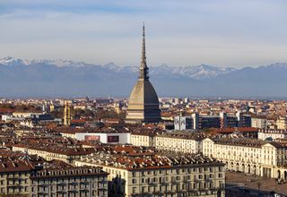 Discover the stunning cityscape of Turin with the iconic Mole Antonelliana and the Alps in the background.
